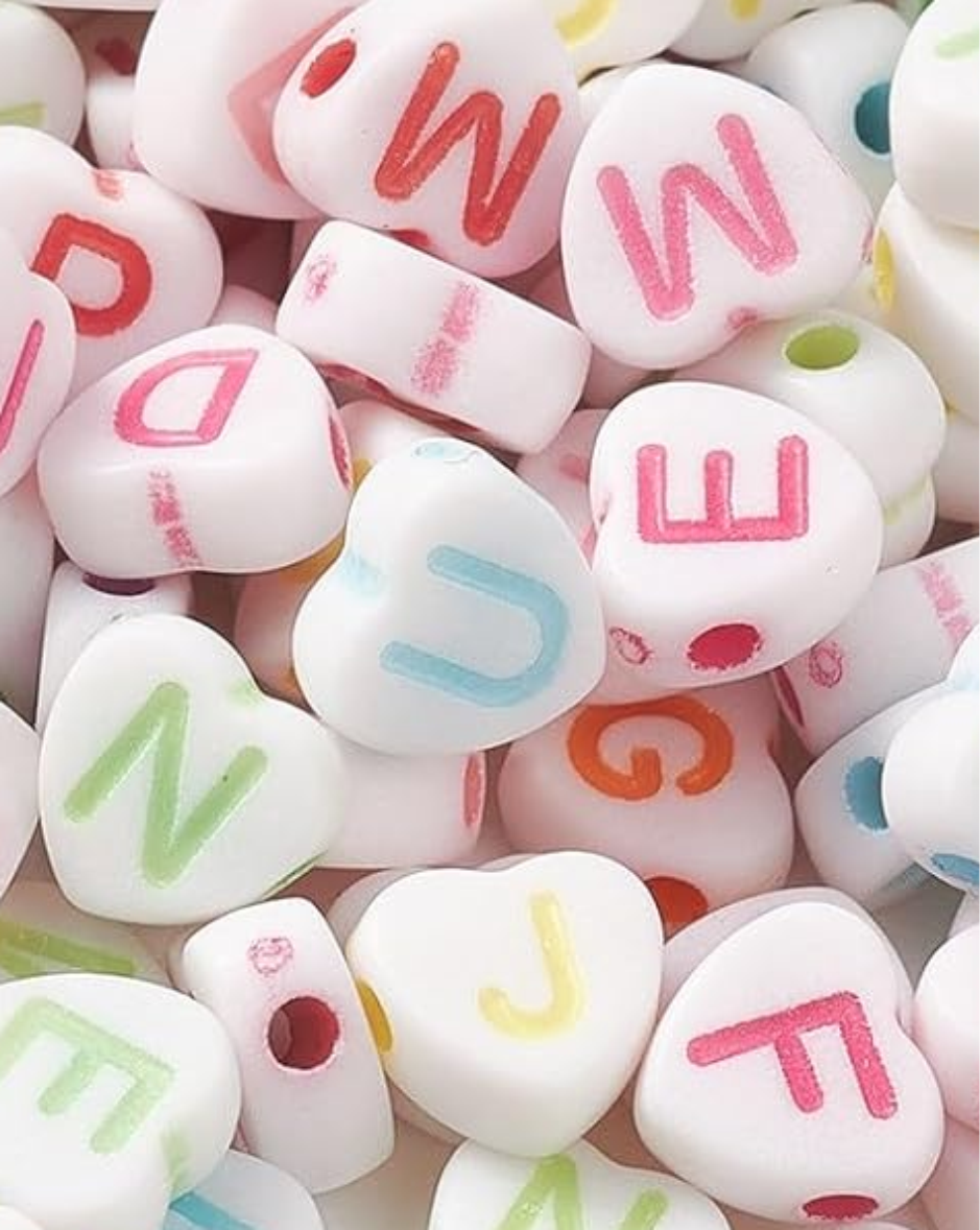 PACK X 2 BOLSITAS DE 100 UN. CUENTAS PLASTICAS CORAZON BLANCO LETRAS COLOR PASTEL 7 MM. 